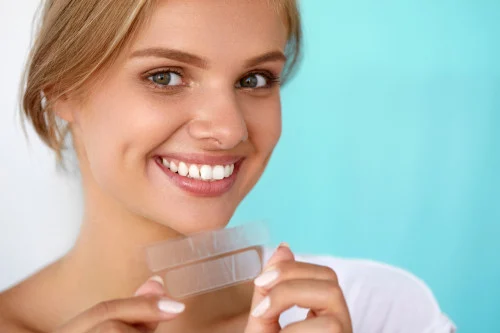 lady smiling holding whitening strip