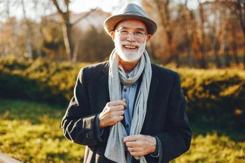 gray haired man smiling in country side