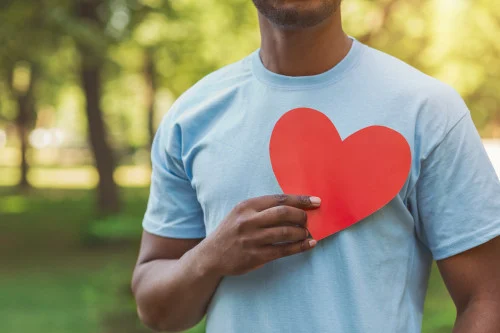 man holding paper heart