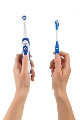 regular toothbrush next to electric toothbrush