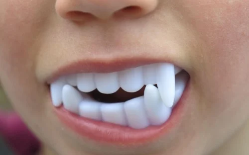 kid with halloween fake teeth in